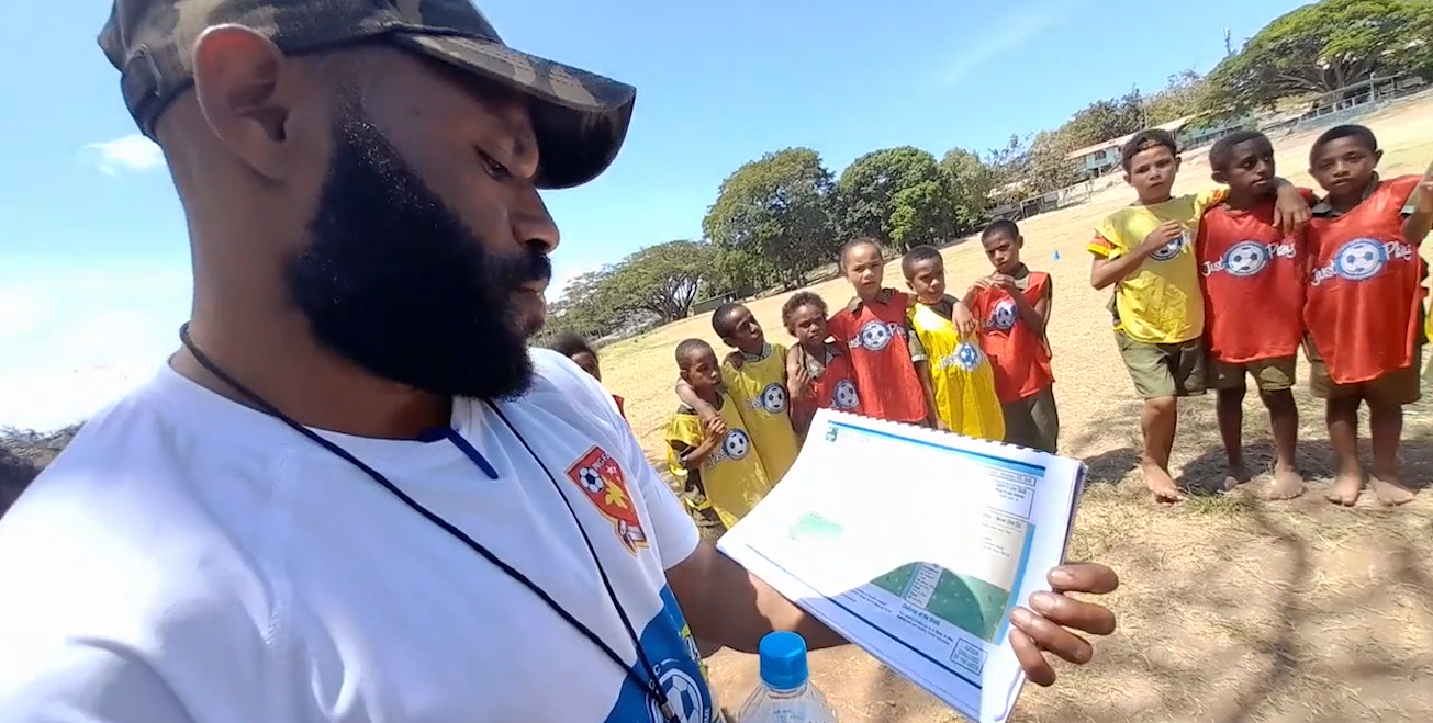 A man in Papua New Guinea coaching football skills