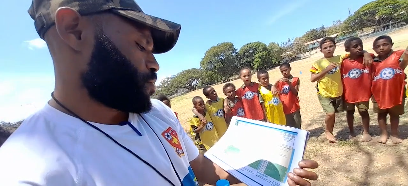 A man in Papua New Guinea coaching football skills