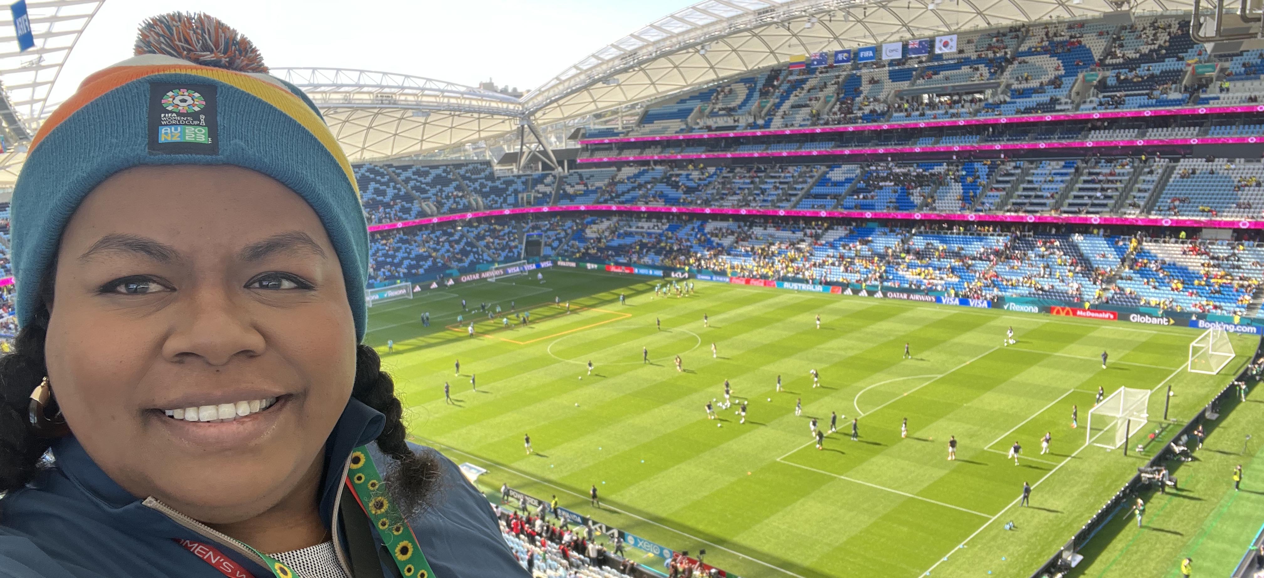 A woman smiling in an empty stadium