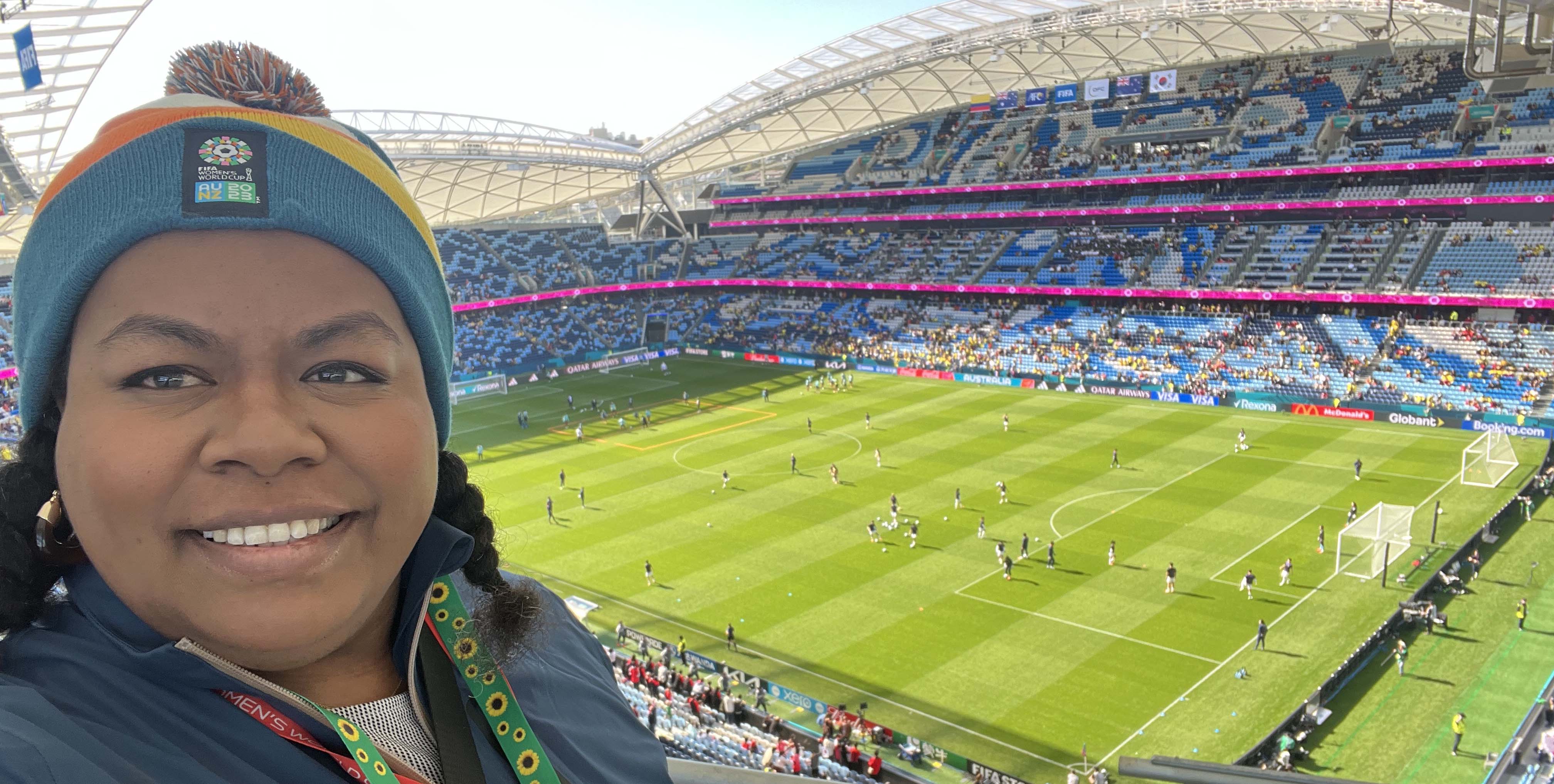 A woman smiling in an empty stadium