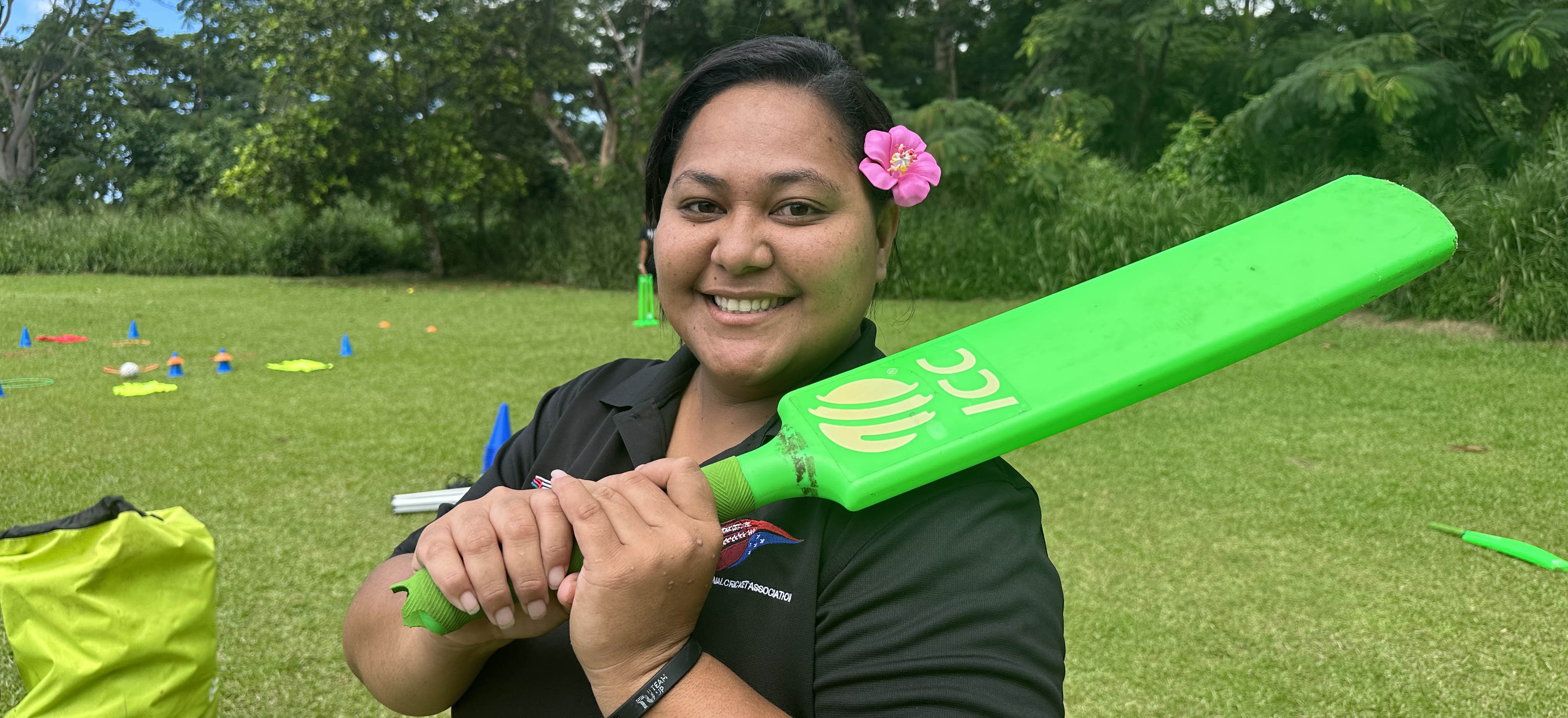 A woman in Samoa holding a cricket bat