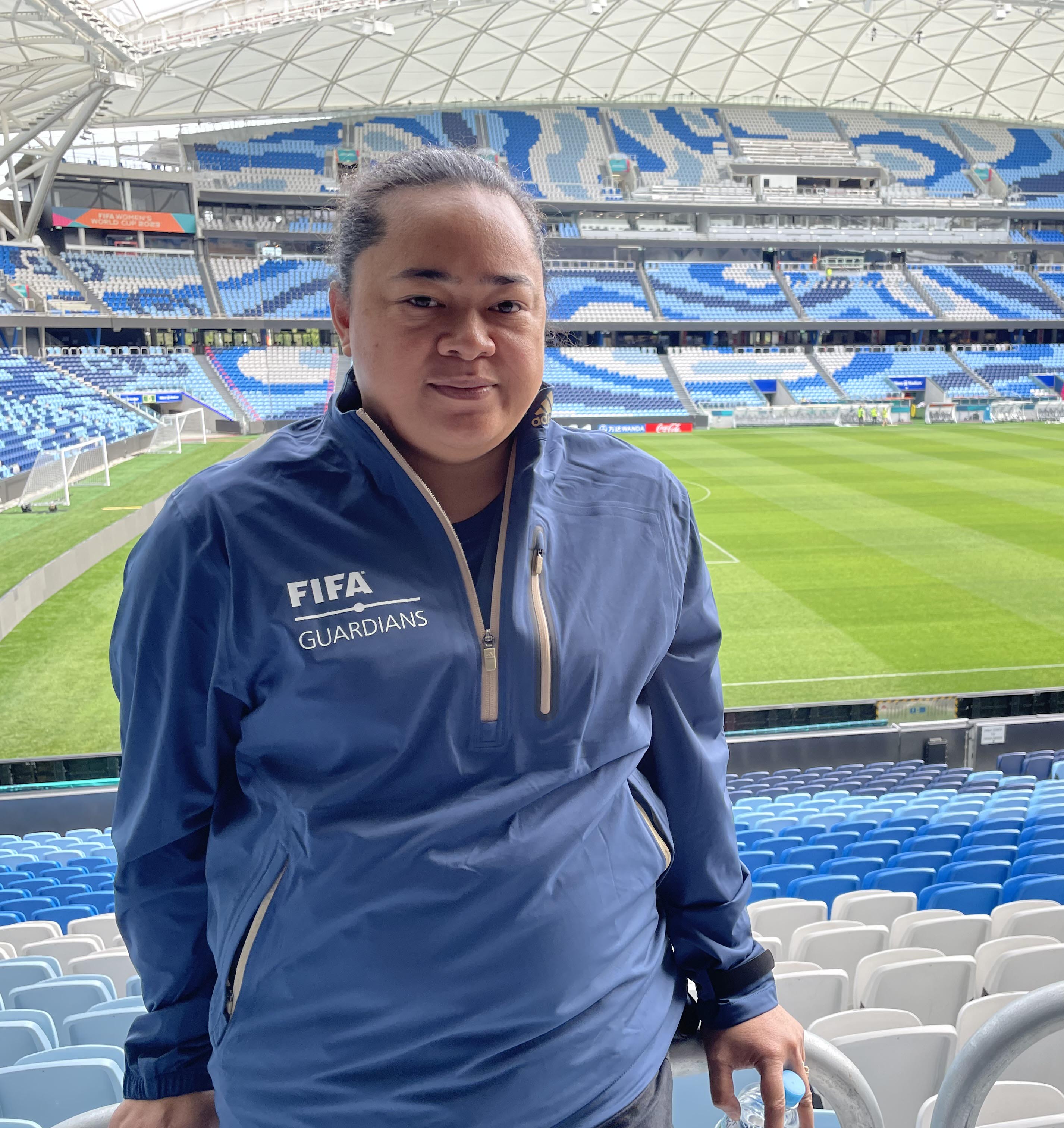 A woman standing inside a stadium