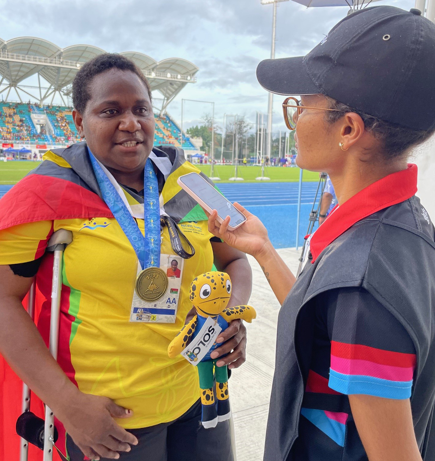 A woman interviewing a Para athlete who has won a gold medal