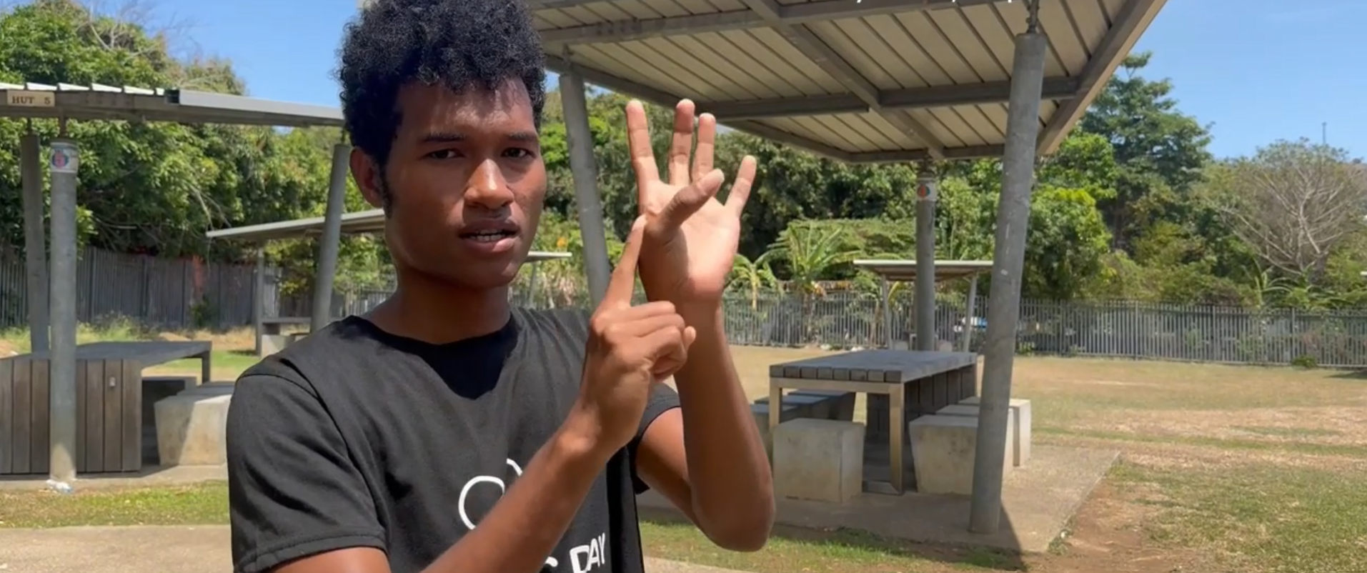 A boy uses sign language